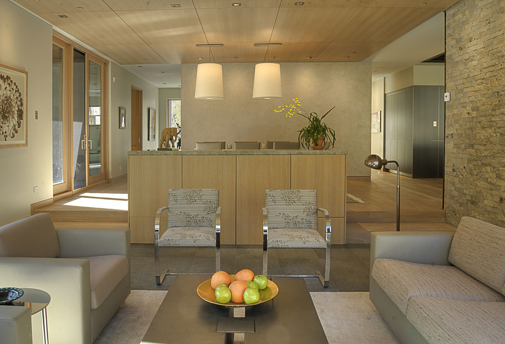 This is an example of a contemporary living room in Denver with a home bar and beige walls.