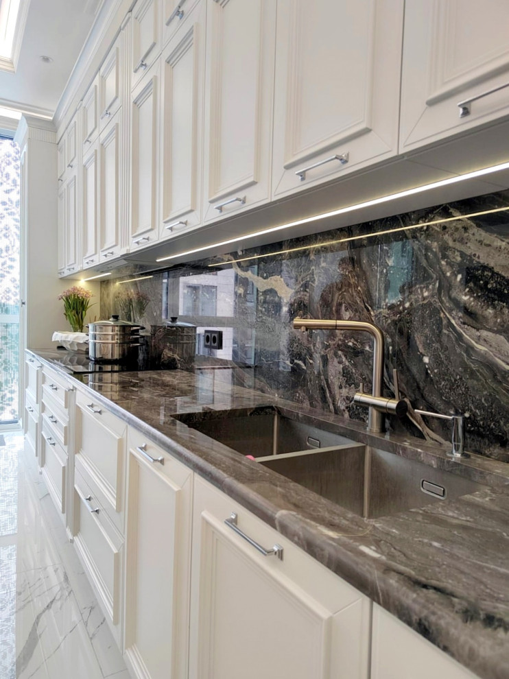 Example of a large transitional single-wall porcelain tile, white floor and tray ceiling eat-in kitchen design in Moscow with a double-bowl sink, recessed-panel cabinets, white cabinets, quartz countertops, black backsplash, quartz backsplash, stainless steel appliances and black countertops