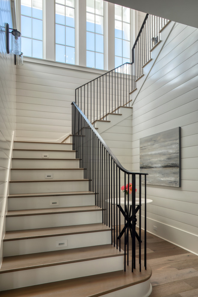 Стильный дизайн: большая п-образная деревянная лестница в стиле неоклассика (современная классика) с деревянными ступенями, металлическими перилами и стенами из вагонки - последний тренд