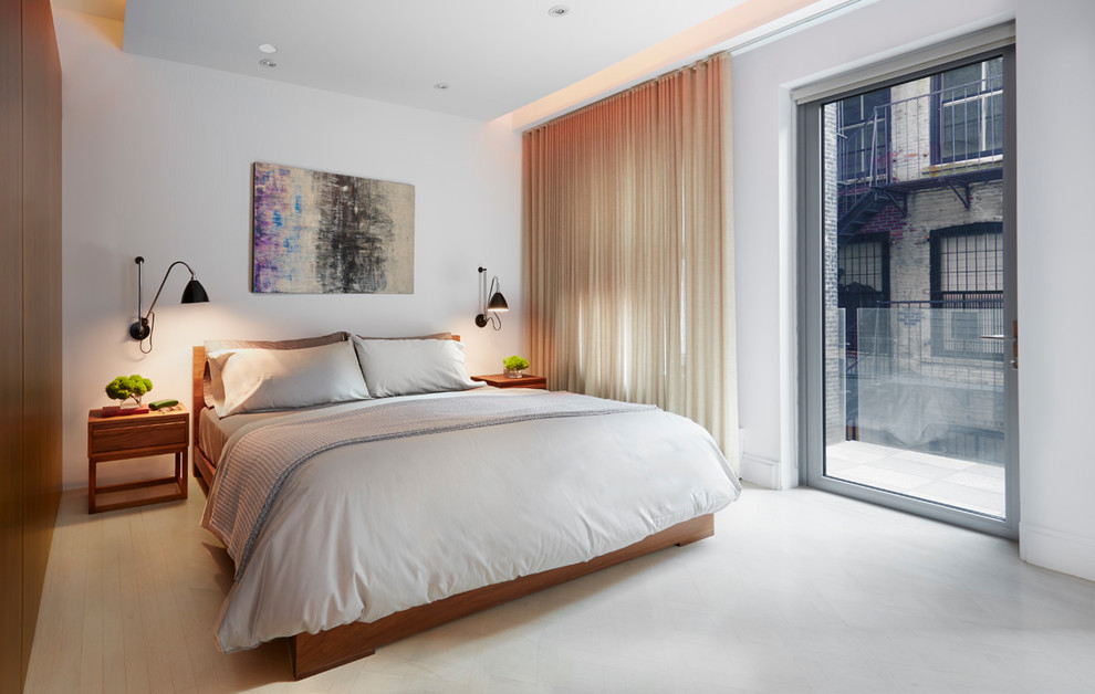 This is an example of a contemporary bedroom in New York with white walls and grey floor.