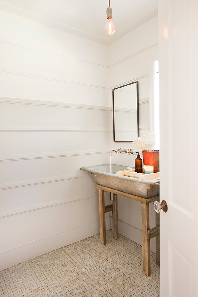 Country powder room in Los Angeles with a trough sink and mosaic tile floors.