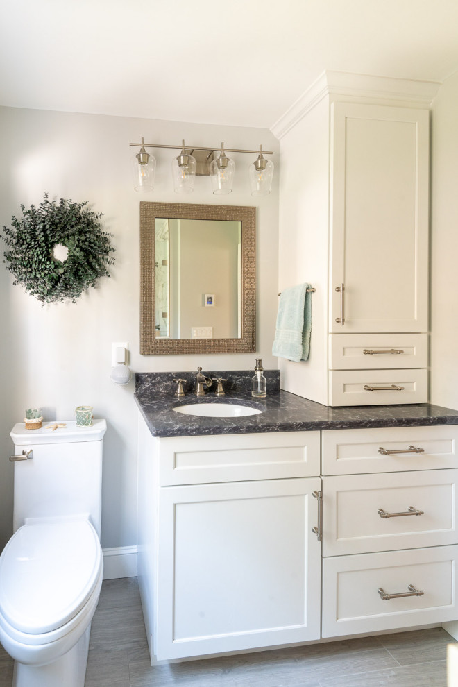 Photo of a mid-sized transitional master bathroom in Boston with shaker cabinets, white cabinets, an alcove shower, a two-piece toilet, multi-coloured tile, porcelain tile, grey walls, porcelain floors, an undermount sink, engineered quartz benchtops, grey floor, a hinged shower door, black benchtops, a niche, a single vanity and a built-in vanity.