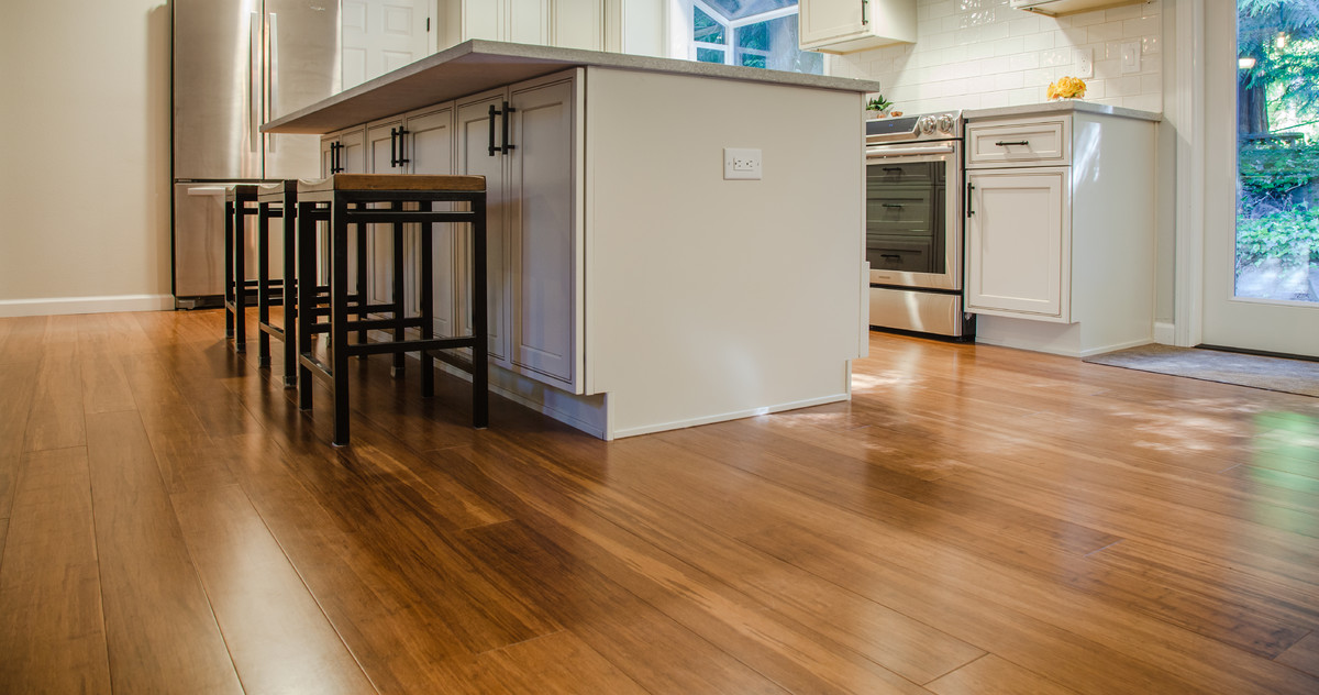 Example of a mid-sized transitional l-shaped bamboo floor and brown floor eat-in kitchen design in Seattle with a double-bowl sink, recessed-panel cabinets, quartz countertops, white backsplash, ceramic backsplash, stainless steel appliances and an island