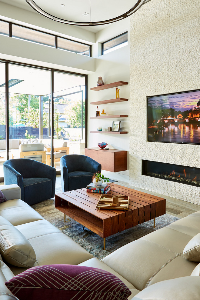Photo of a modern living room in San Francisco with a standard fireplace, a metal fireplace surround and a built-in media wall.