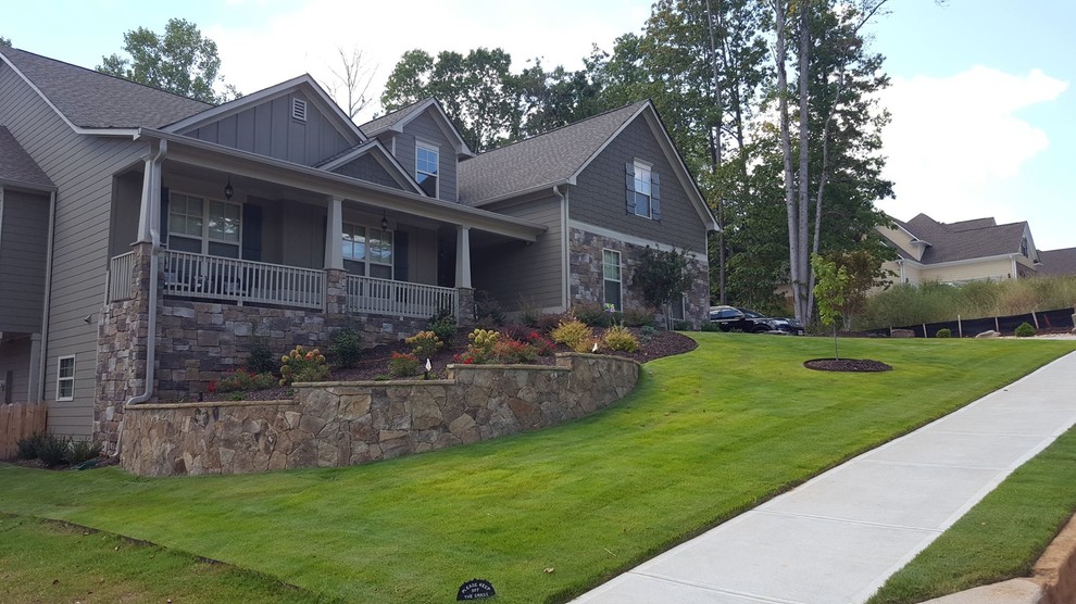 Photo of a large arts and crafts sloped full sun xeriscape for spring in Atlanta with a retaining wall.