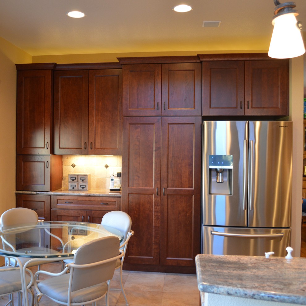 Transitional u-shaped eat-in kitchen photo in Denver with an undermount sink, recessed-panel cabinets, medium tone wood cabinets, granite countertops, beige backsplash, stone tile backsplash, stainless steel appliances and a peninsula