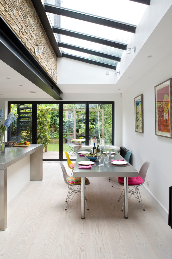 Inspiration for a contemporary open plan dining in London with white walls, light hardwood floors, no fireplace and beige floor.