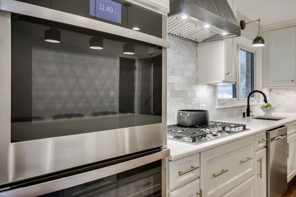 Inspiration for a large transitional u-shaped kitchen in DC Metro with an undermount sink, recessed-panel cabinets, white cabinets, quartz benchtops, stainless steel appliances, medium hardwood floors and with island.