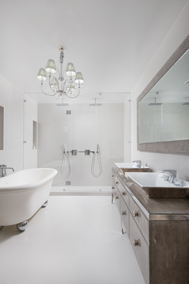 Large modern master bathroom in New York with flat-panel cabinets, brown cabinets, a freestanding tub, a double shower, a one-piece toilet, beige tile, ceramic tile, beige walls, ceramic floors, a vessel sink, glass benchtops, beige floor and a hinged shower door.