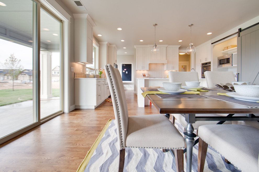 Example of a large transitional light wood floor eat-in kitchen design in Boise with shaker cabinets, white cabinets, quartzite countertops, stainless steel appliances and an island