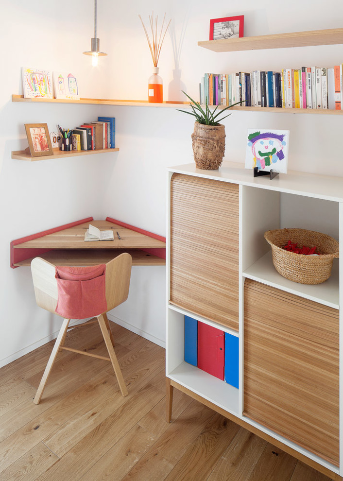 Inspiration for a contemporary home office in Milan with white walls, light hardwood floors and a built-in desk.