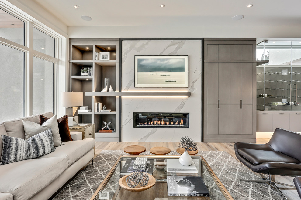 Photo of a large contemporary open concept living room in Calgary with a stone fireplace surround, a home bar, light hardwood floors and a ribbon fireplace.