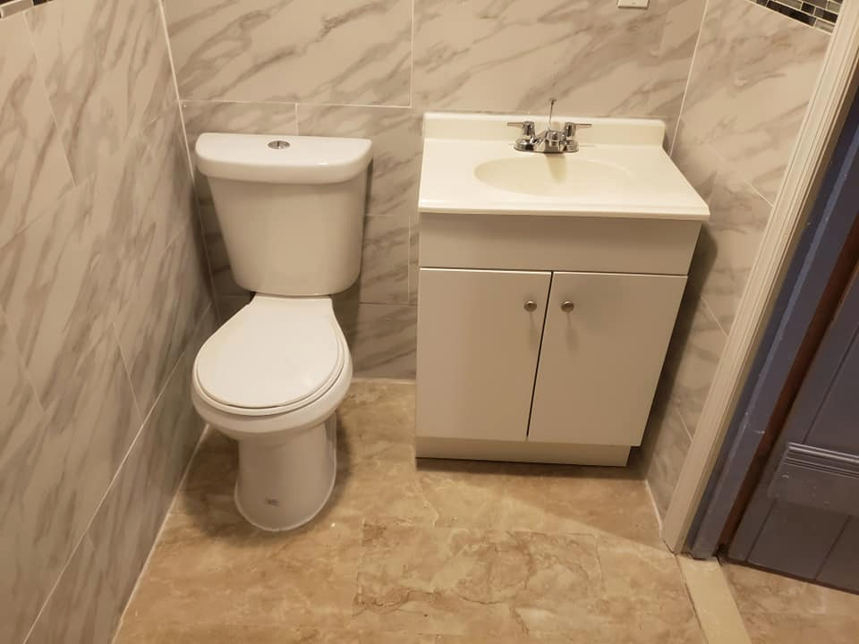 This is an example of a mid-sized contemporary 3/4 bathroom in Newark with open cabinets, white cabinets, a hot tub, a corner shower, a one-piece toilet, beige tile, ceramic tile, beige walls, ceramic floors, a drop-in sink, solid surface benchtops, beige floor, a shower curtain, white benchtops, a single vanity, a built-in vanity and vaulted.