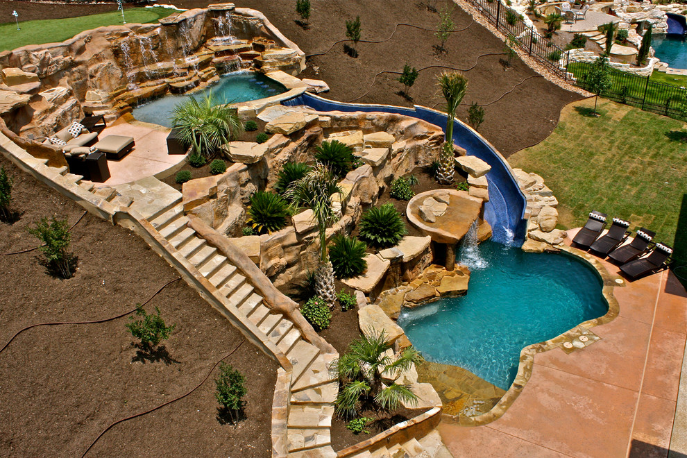 Photo of a large contemporary backyard custom-shaped natural pool in Austin with a water slide and decking.