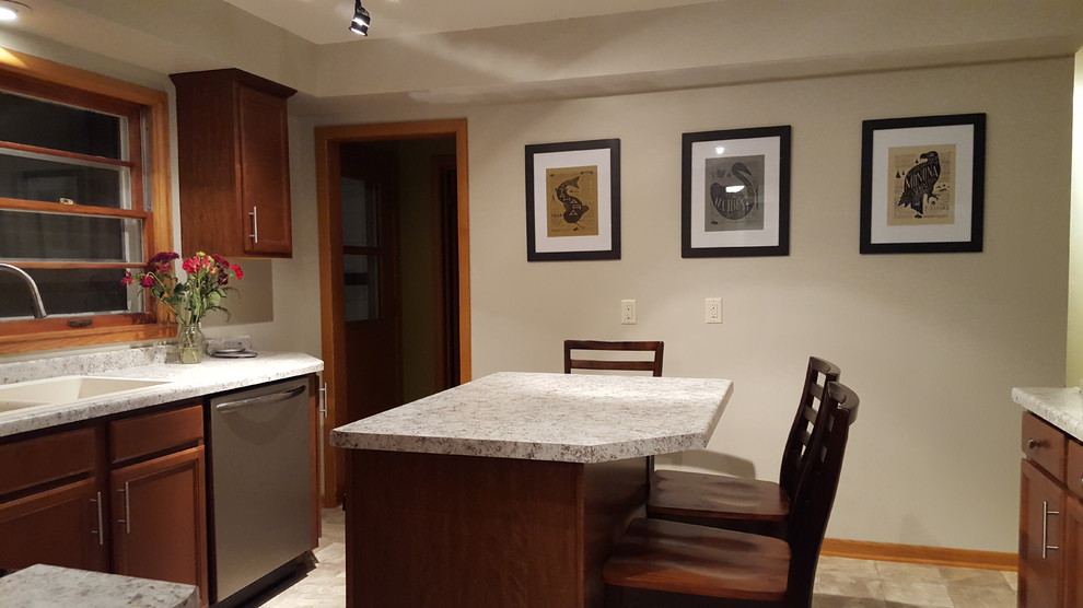 Mid-sized transitional l-shaped vinyl floor enclosed kitchen photo with a drop-in sink, recessed-panel cabinets, medium tone wood cabinets, laminate countertops, stainless steel appliances and an island