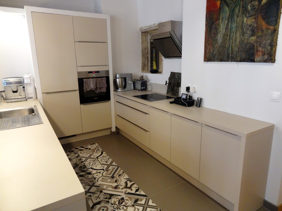 This is an example of a small contemporary u-shaped kitchen in Lyon with a single-bowl sink and laminate benchtops.