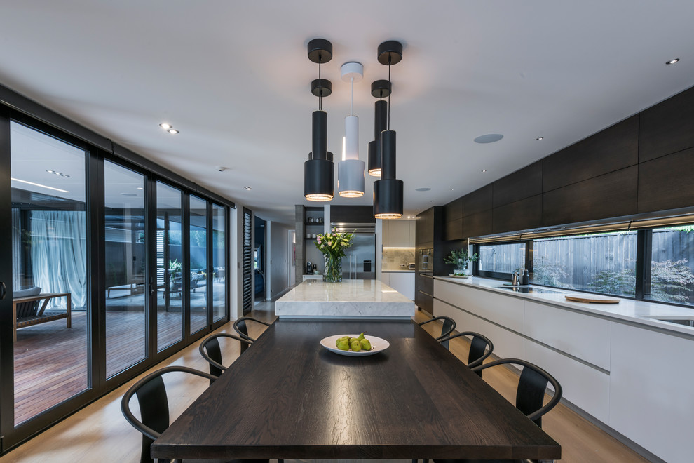 This is an example of a contemporary kitchen/dining combo in Christchurch with light hardwood floors.