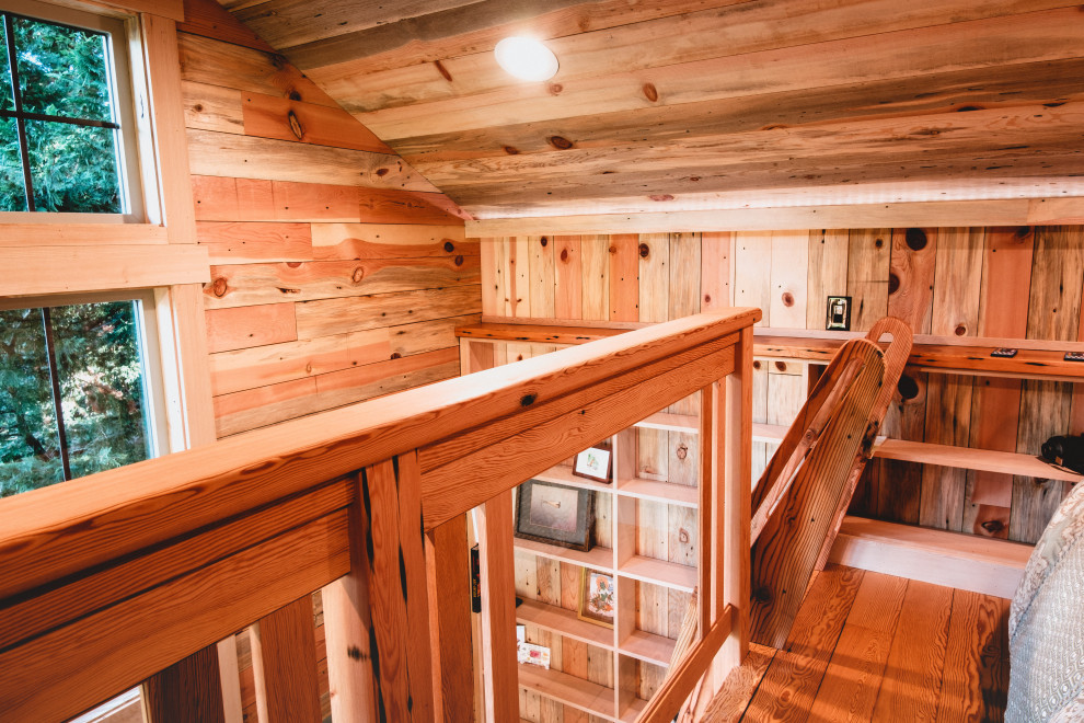 This is an example of a small country home studio in Seattle with multi-coloured walls, medium hardwood floors, a freestanding desk, multi-coloured floor, timber and decorative wall panelling.