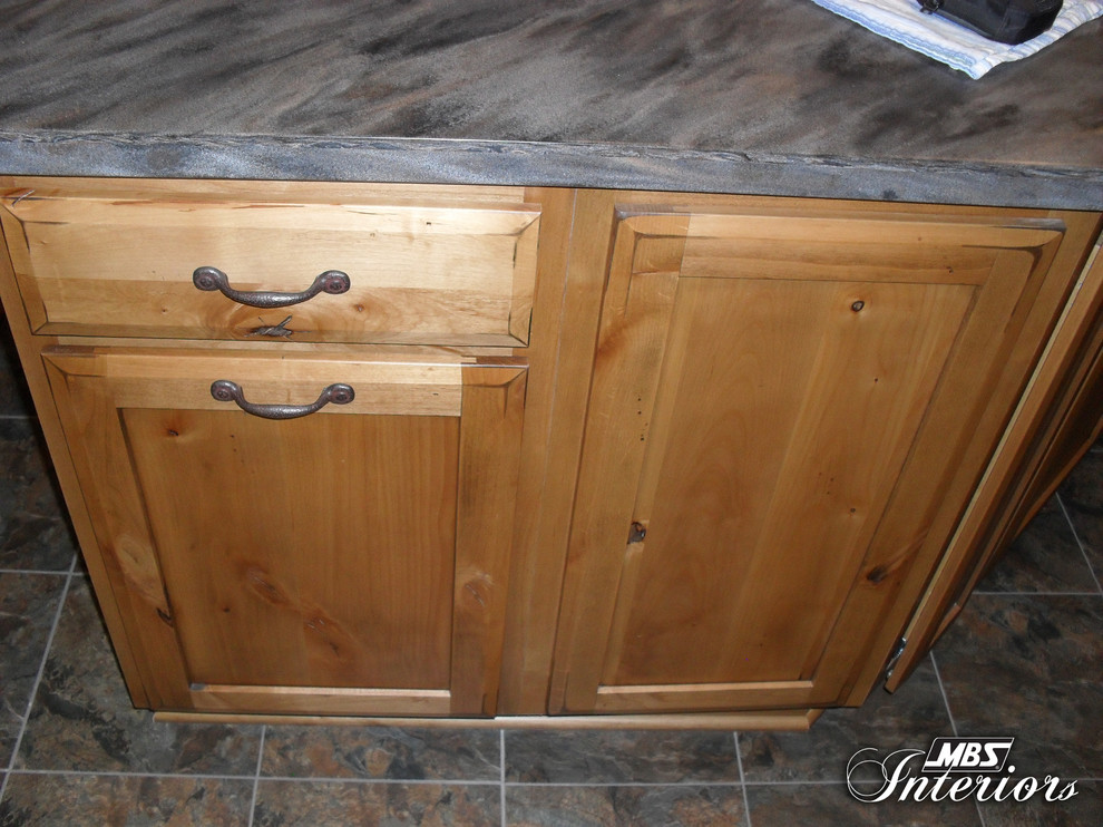 Eat-in kitchen - rustic l-shaped eat-in kitchen idea with a double-bowl sink, shaker cabinets, medium tone wood cabinets, solid surface countertops, white backsplash and black appliances