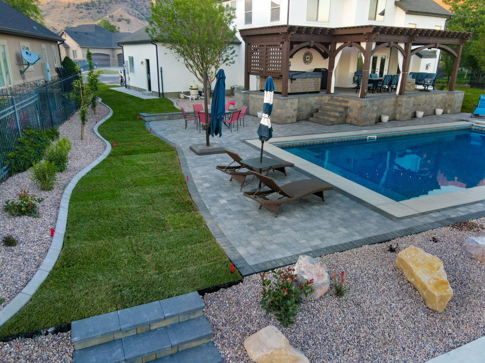 Medium sized classic back custom shaped swimming pool in Salt Lake City with with pool landscaping and brick paving.