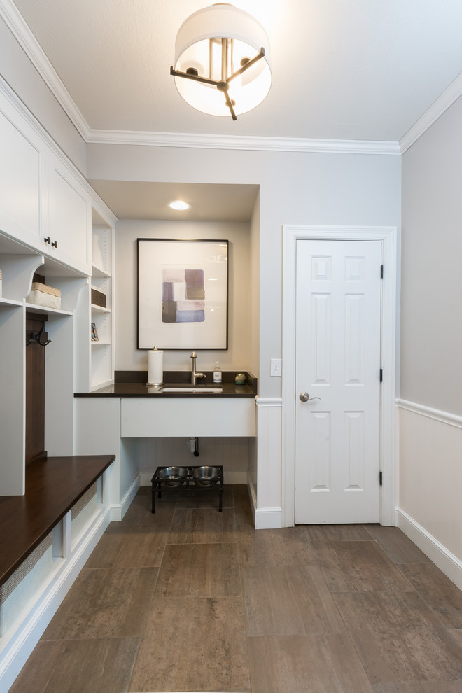 Example of a mid-sized transitional porcelain tile mudroom design in Columbus with white walls and a white front door