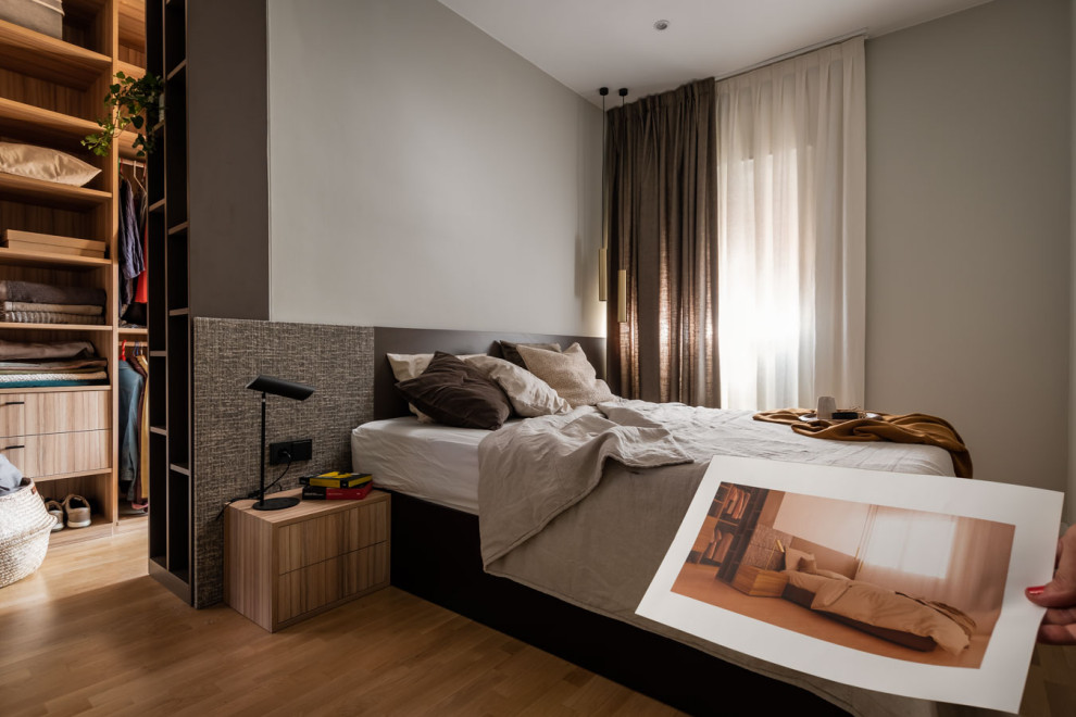 Mid-sized contemporary master bedroom in Barcelona with beige walls and medium hardwood floors.