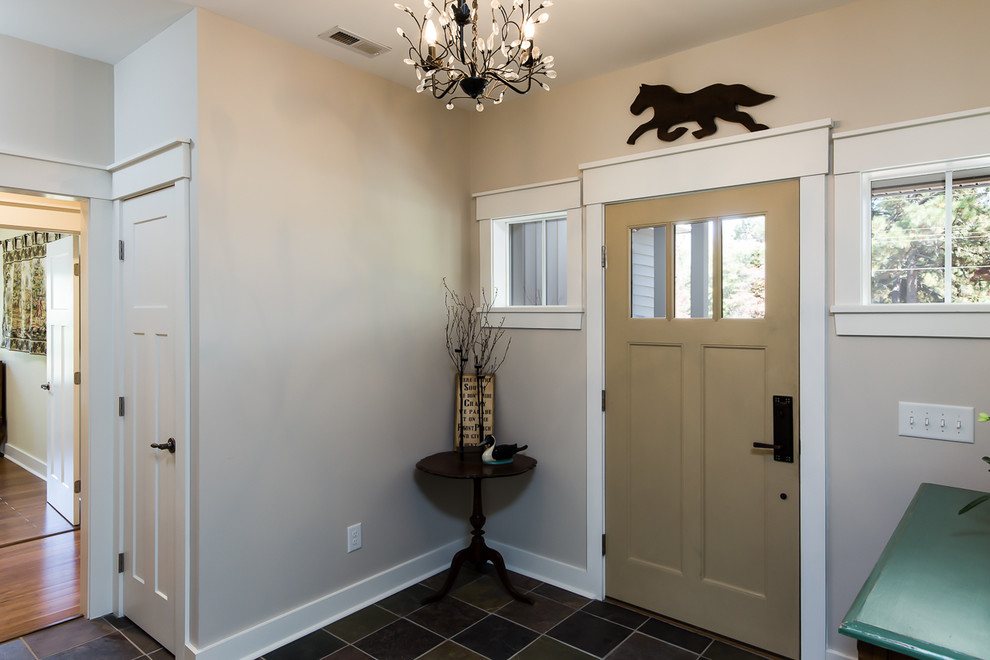Photo of a mid-sized arts and crafts foyer in Raleigh with beige walls, slate floors, a single front door and a yellow front door.