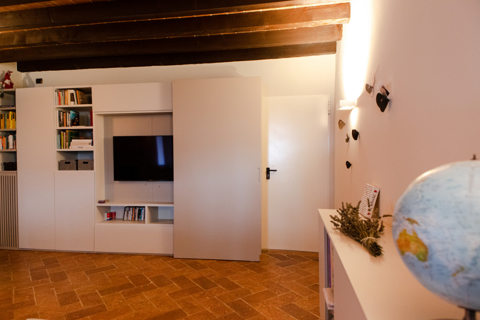 Photo of a large country mezzanine games room in Milan with a reading nook, white walls, terracotta flooring, a standard fireplace, a brick fireplace surround, a built-in media unit, red floors, exposed beams and brick walls.