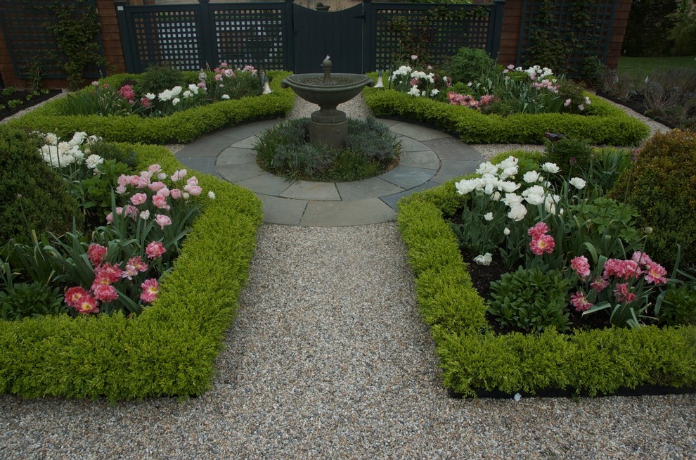Small traditional backyard full sun formal garden in Charlotte with a water feature and gravel for spring.