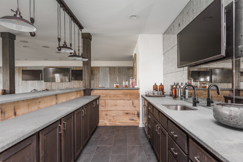 Photo of a large country l-shaped wet bar in Indianapolis with a drop-in sink, light wood cabinets, concrete benchtops, multi-coloured splashback, glass sheet splashback, ceramic floors and grey floor.