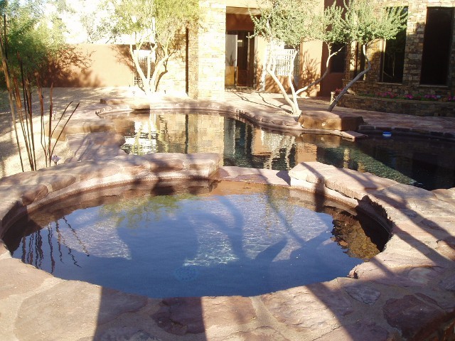 Example of a mid-sized backyard stone and kidney-shaped hot tub design in Phoenix