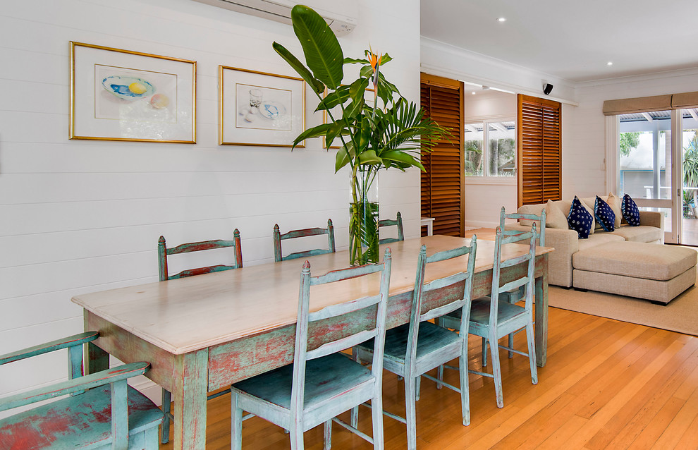 Inspiration for a mid-sized tropical open plan dining in Gold Coast - Tweed with white walls and medium hardwood floors.