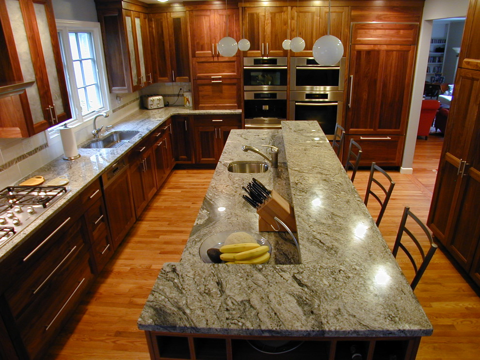 Large traditional u-shaped separate kitchen in Boston with an undermount sink, recessed-panel cabinets, dark wood cabinets, granite benchtops, panelled appliances, dark hardwood floors, with island and brown floor.