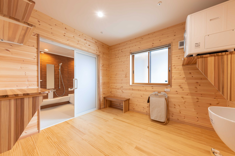 Geräumiges Badezimmer En Suite mit brauner Wandfarbe, hellem Holzboden, braunem Boden, Wäscheaufbewahrung, Tapetendecke und vertäfelten Wänden in Sonstige