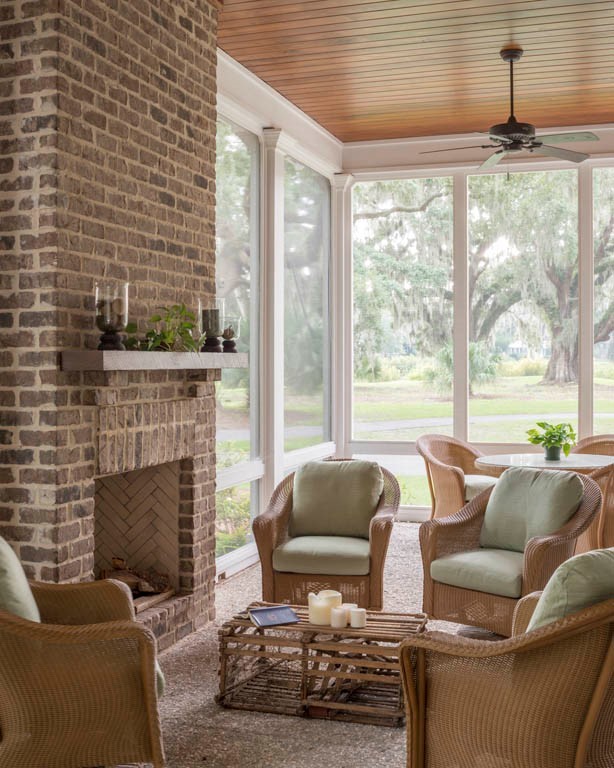 This is an example of a large traditional sunroom in Atlanta with concrete floors, a standard fireplace, a brick fireplace surround and a standard ceiling.