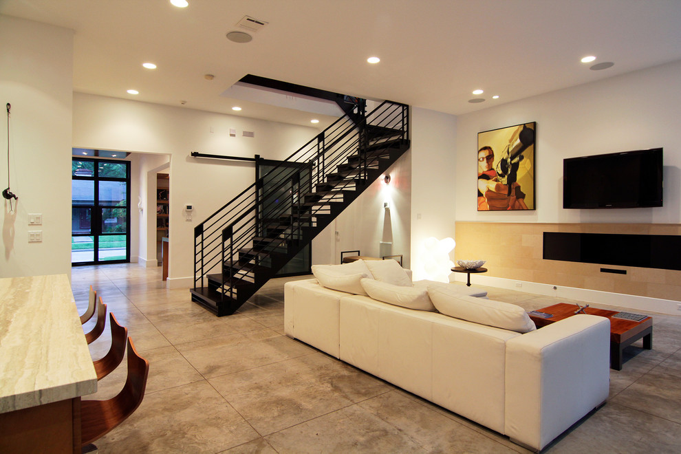 This is an example of a contemporary family room in Houston with concrete floors.