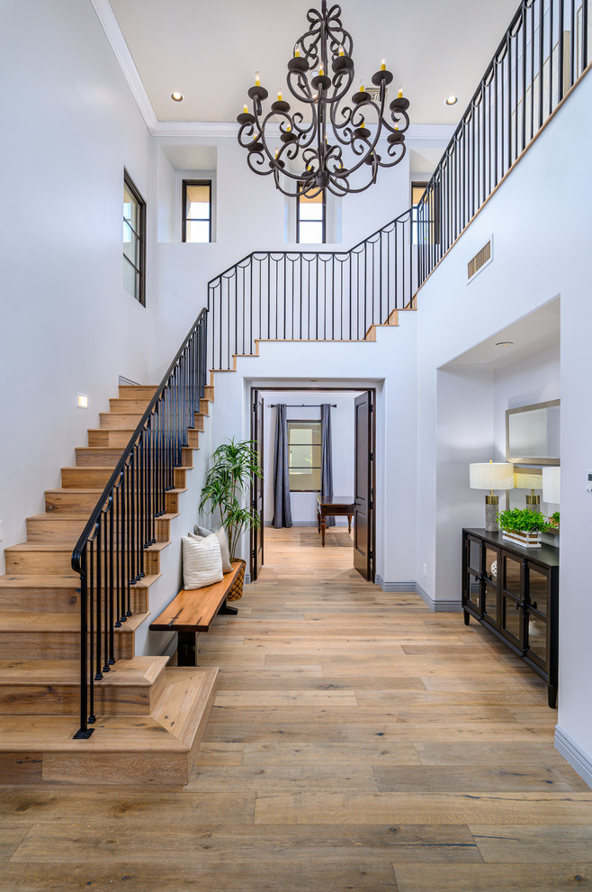 Large transitional light wood floor foyer photo in Phoenix with gray walls and a black front door
