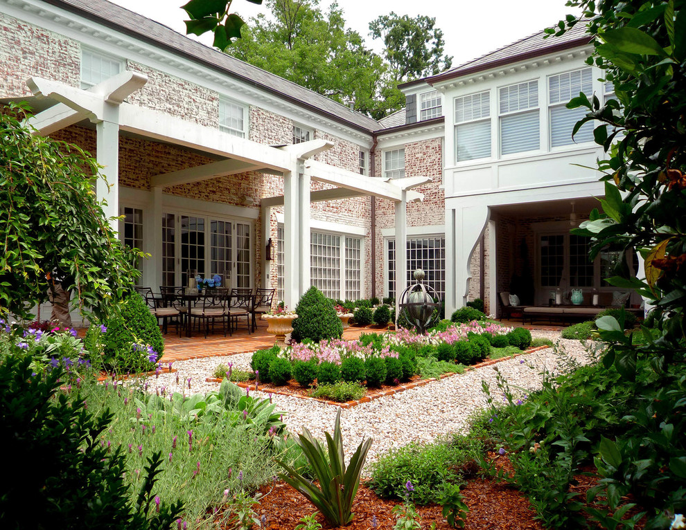 Traditional courtyard formal garden in Charlotte with gravel.
