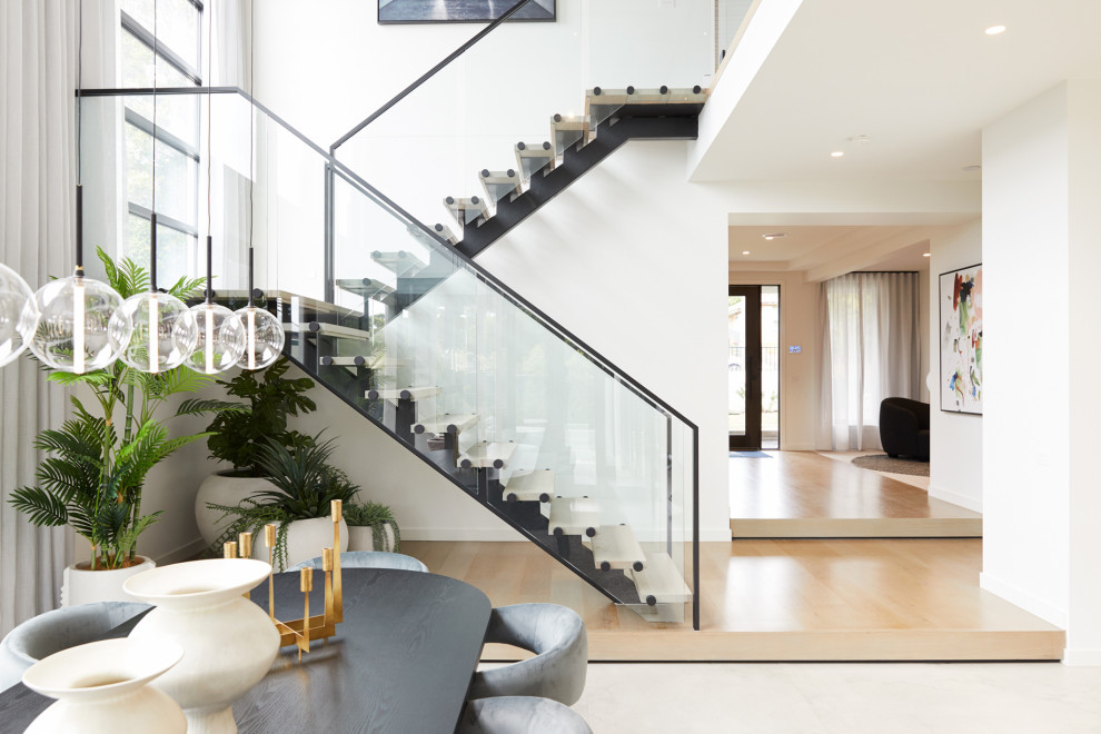 Large contemporary wood u-shaped staircase in Melbourne with open risers and metal railing.