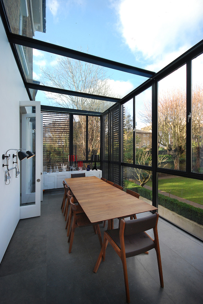 Photo of a large contemporary sunroom in London with a glass ceiling and grey floor.
