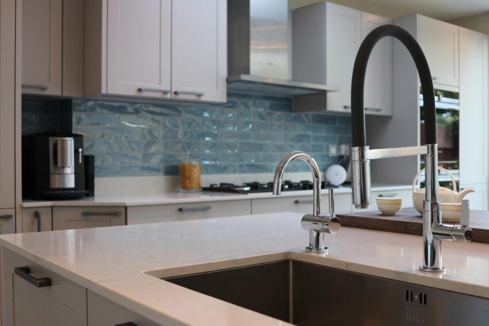 Inspiration for a large traditional single-wall eat-in kitchen in London with a drop-in sink, shaker cabinets, quartzite benchtops, ceramic splashback, panelled appliances, with island and white benchtop.