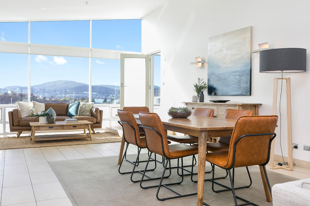 Contemporary open plan dining in Hobart with white walls and beige floor.