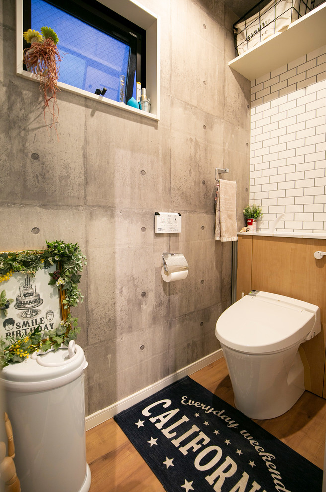 Industrial powder room in Osaka with open cabinets, white tile, multi-coloured walls, medium hardwood floors and brown floor.
