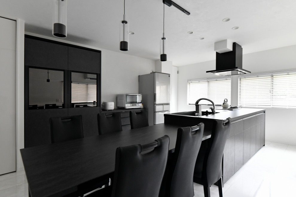 This is an example of a mid-sized modern single-wall eat-in kitchen in Fukuoka with an integrated sink, flat-panel cabinets, black cabinets, black appliances, plywood floors, with island, white floor, black benchtop and wallpaper.