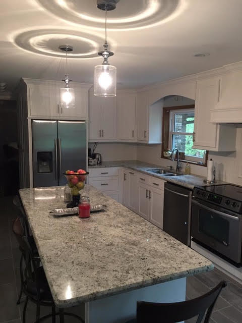 Eat-in kitchen - large transitional u-shaped gray floor eat-in kitchen idea in Birmingham with a double-bowl sink, shaker cabinets, white cabinets, white backsplash, stainless steel appliances and an island