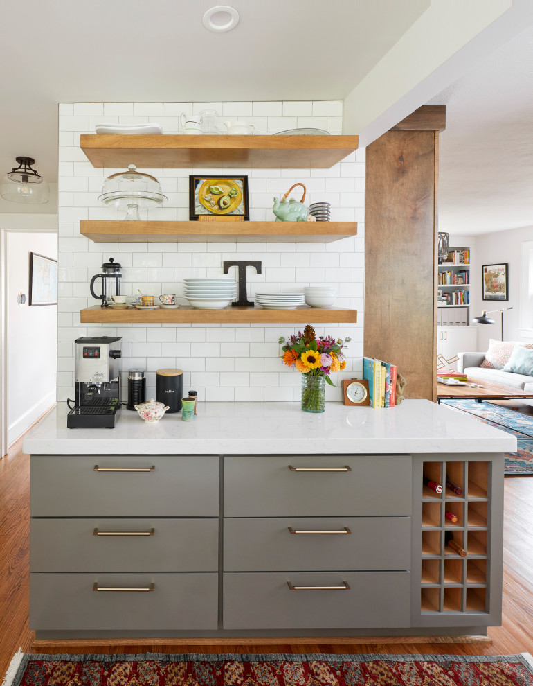 Mid-sized transitional galley medium tone wood floor and brown floor eat-in kitchen photo with a farmhouse sink, shaker cabinets, gray cabinets, quartz countertops, white backsplash, subway tile backsplash, stainless steel appliances, no island and white countertops