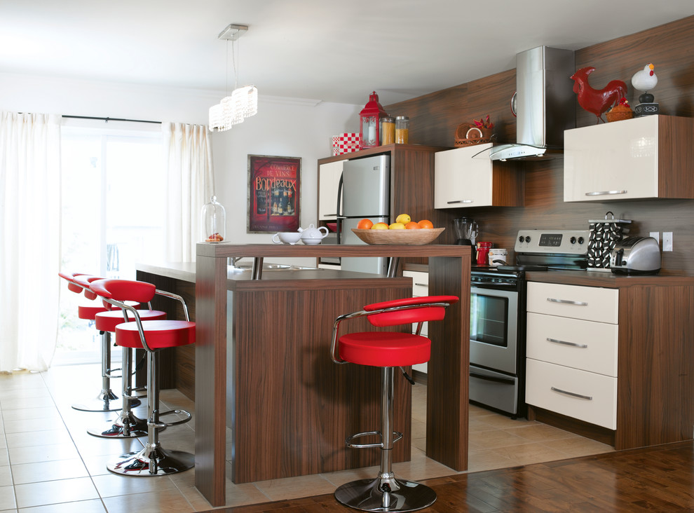 Photo of a contemporary galley kitchen in Montreal with flat-panel cabinets, white cabinets, wood benchtops, stainless steel appliances and with island.