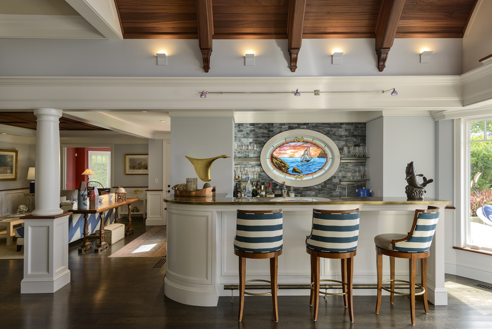 Design ideas for an expansive beach style seated home bar in Boston with dark hardwood floors, an undermount sink, white cabinets, marble benchtops, blue splashback and glass tile splashback.