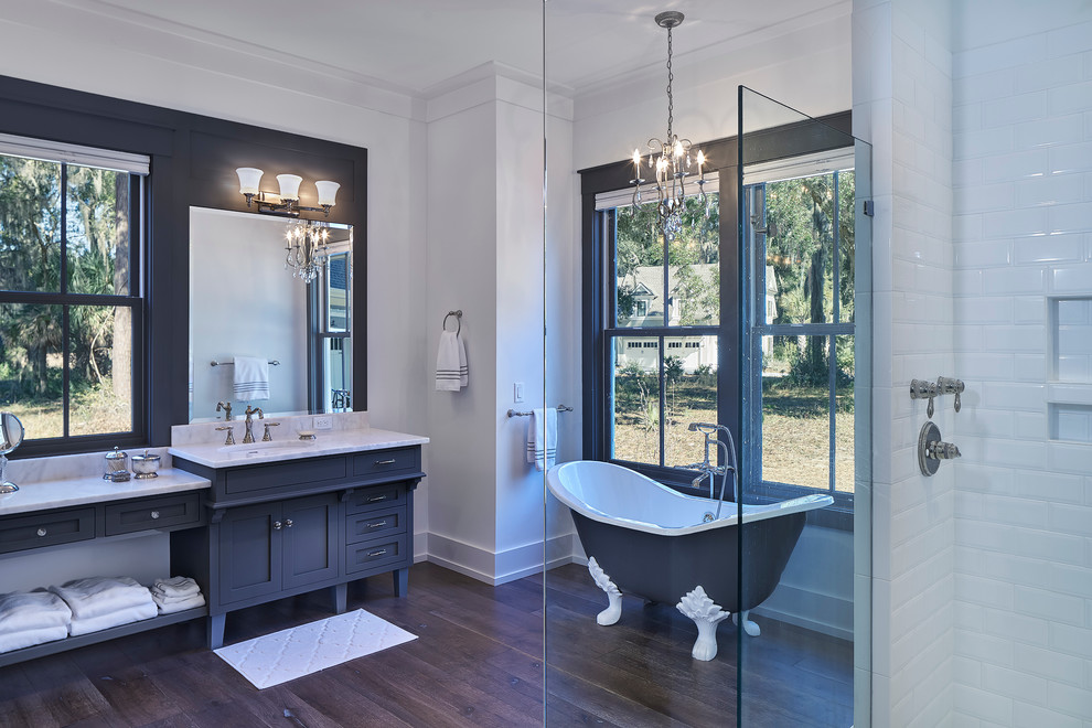 This is an example of a large transitional master bathroom in Atlanta with shaker cabinets, grey cabinets, a claw-foot tub, a corner shower, a two-piece toilet, white tile, subway tile, white walls, dark hardwood floors, an undermount sink and marble benchtops.