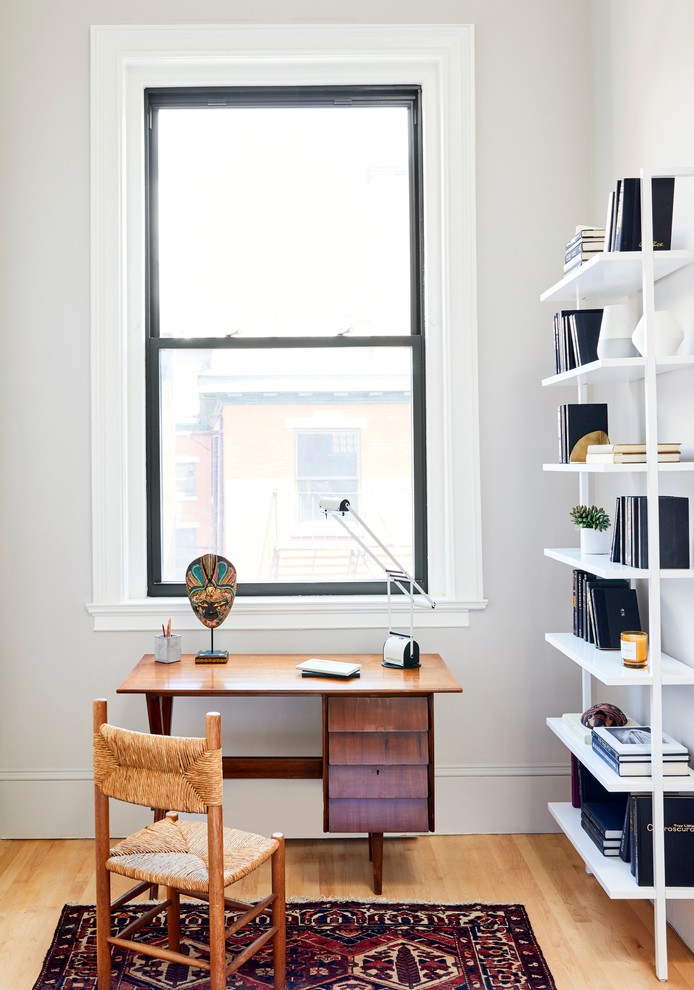 This is an example of a small scandinavian study room in Providence with light hardwood floors, a freestanding desk, grey walls and no fireplace.